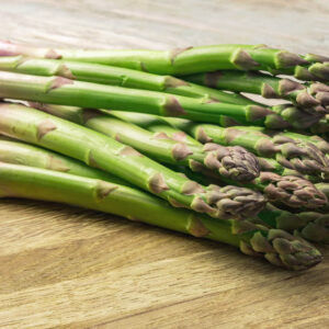 A bunch of freshly cut Mary Washington Asparagus laying on a wooden bench