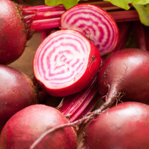A pile of Chioggia beetroots with one cut open to see the bulls eye