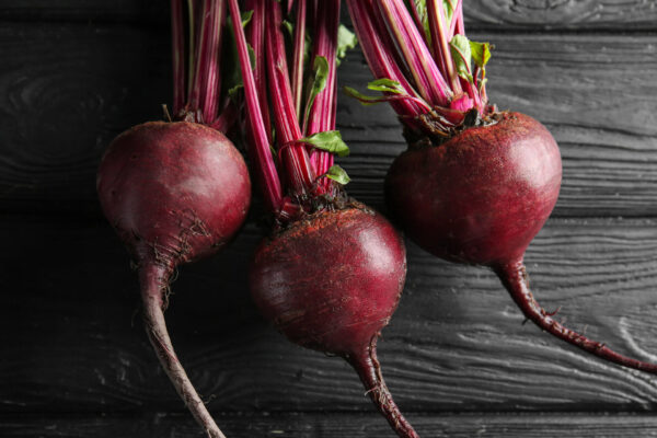 Three Detroit Dark Red Beetroots on a black table top
