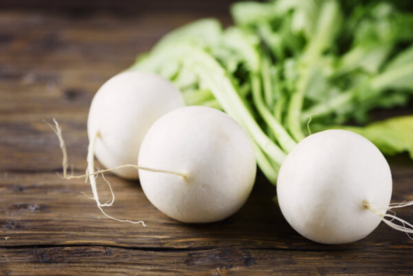 Three Tokyo White Cross turnips on a wooden table